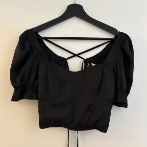 Topp - Kortärmad topp med knytning i ryggen. Fint skick