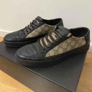 GG Supreme Monogram Mens Sneakers Black  - Mycket fina Gucci skor som passar in vid fina tillfällen. Storleken är 42,5 och inga stora skador alls. Använd ett par tillfällen vid bröllop. Men har köpt in nya finskor så dessa har legat i garderoben ett tag nu.
