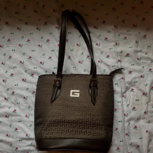Vintage väska - söt brun väska med silvriga detaljer som påminner om guess. I perfekt skick aldrig används. Säljer pga att den inte kommer till användning! 💕