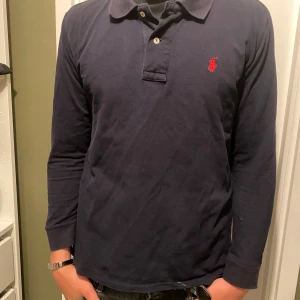 Polo tröja - As snygg polo Ralph lauren tröja i mörkblå färg. Har en liten defekt på vänster arm, därav det billiga priset. Skriv vid minsta fundering!
