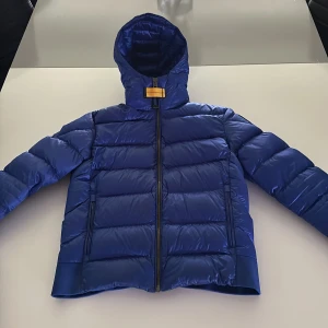 Parajumper jacka  - Nypris 7000kr.  Skick 10/10. Storlek 152 fast den kan även passa de människor som bär storlek 158. Rensar garderoben. Jackan har en glänsande blå färg på utsidan och en vit färg på insidan och denna färg kan du inte hitta någon annan stans. 