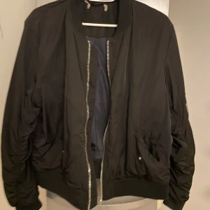 Bomberjacka  - Svart bomberjacka, kortare modell i storlek xl.  Fodrad så den passar perfekt till höst och vår.