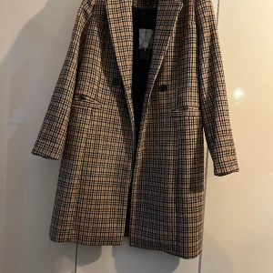 Kappa - En rutig kappa från Vero Moda Fick den av min moster som inte kunde ha den då den var för liten och stygnen gick upp i ryggen men det har vi sytt igen (se bild 3), personligen tycker jag inte att det syns. Aldrig använt själv, prislappen sitter kvar