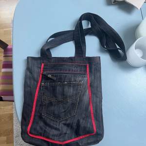 En egensydd väska från ett par jeans med röda detaljer 🤍 rymlig med många fack på in- och utsidan 