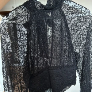 Spetstopp från Zara - Svart blus i spets från Zara. Knytning i nacken och öppen rygg. Så himla fin. Använd endast 1 gång.