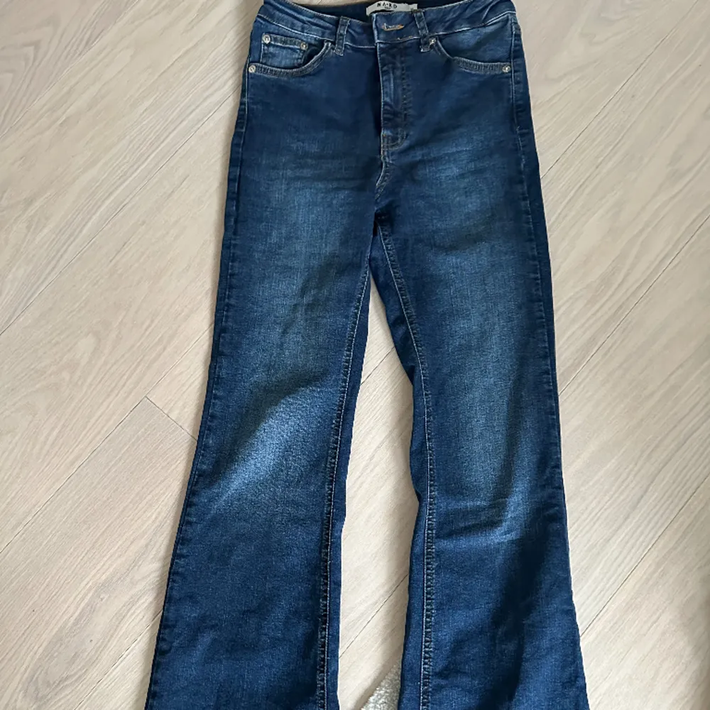 Mörkblåa jeans med slits på baksidan av jeansen nere vid ”hälen” . Jeans & Byxor.