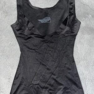 Svart Linne - Ett svart, tajt, urringat linne, shapewere. 🖤💕Linnet är oanvänt i perfekt skick😊💓Passar mig tyvärr inte i storlek. Man kan ha det bak och fram så får man en öppen rygg. Priset är diskuterbart🙌💗