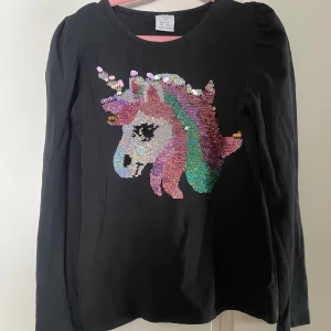 Tröja med vändbara paljetter  - Lindex, 116, inga hål eller fläckar, blekare än ny. Kommer från ett rökfritt hem, katt finns i hemmet och jag tvättar inte parfymfritt. 