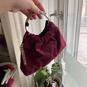 Vinröd handväska med guld detaljer