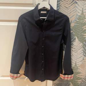 Klassisk Burberry skjort i svart, går aldrig fel och perfekt nu inför sommaren. Retail: ca 5500kr. Passa på! Allt gott, mvh W