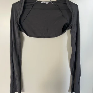 Bolero - Långärmad mörkgrå bolero, lång i ärmarna, snygg passform, gjord av väldigt skönt och tunt tyg 