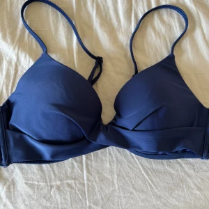 Mörkblå bikini överdel - Marinblå bikini överdel från Nelly. Snurrad i fram. Lite push up. Storlek 80b. Nypris 250kr. Pris kan diskuteras. Helt oanvänd. 