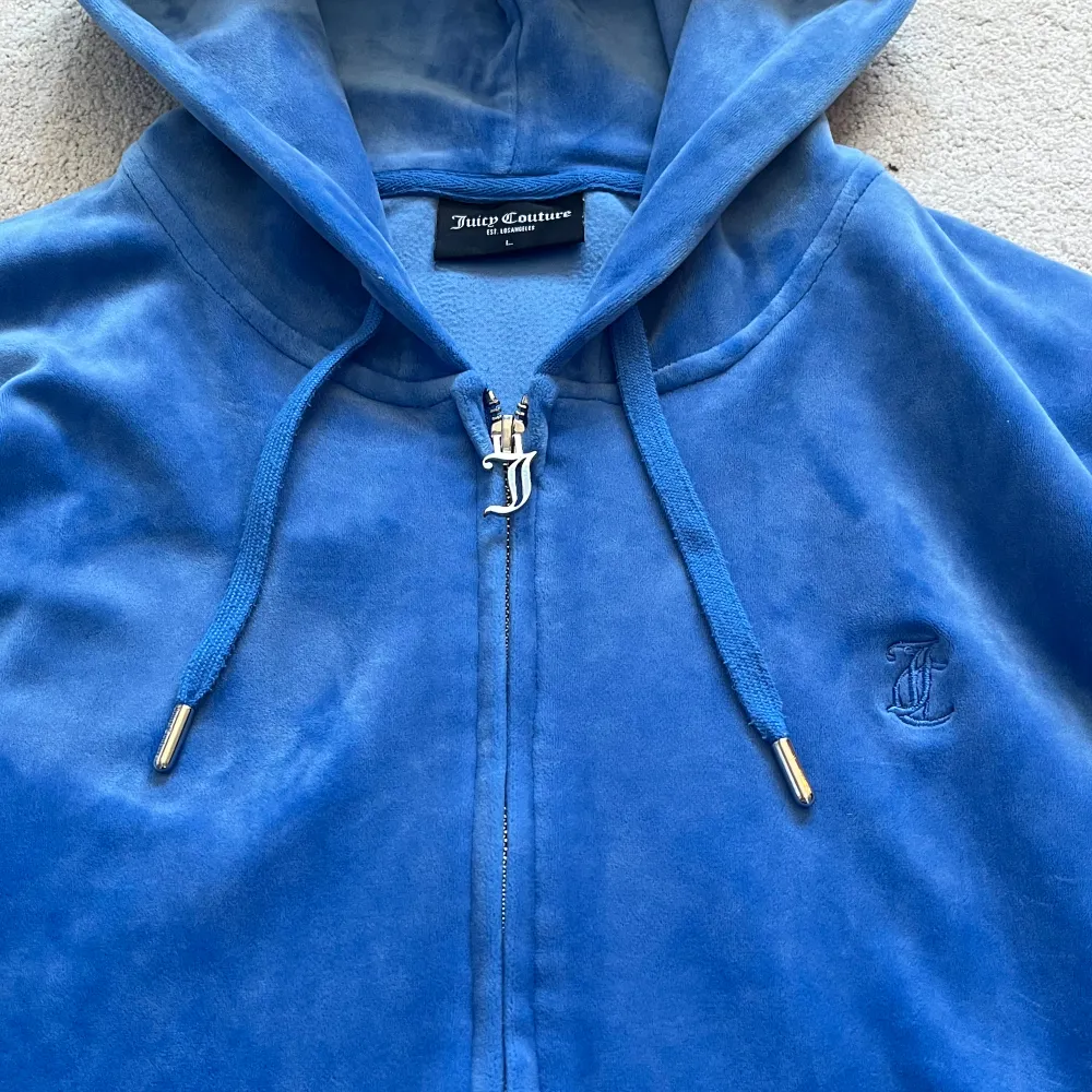 Säljer den här blåa Juicy Couture zip hoodien då den inte kommer till användning längre och bara ligger i min garderob, så skönt material och sitter verkligen perfekt😍Storleken är L men sitter som M och S skulle jag säga! jättebra skick🥰. Hoodies.