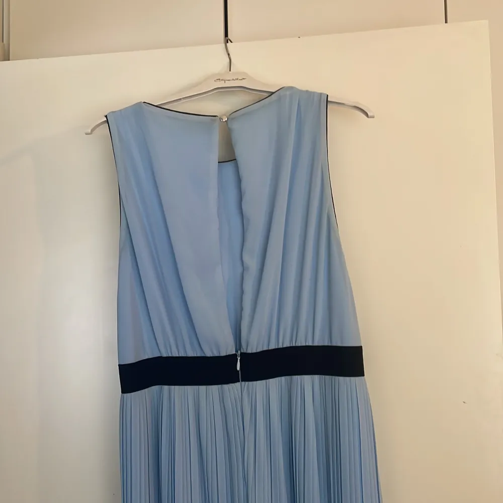 Ljus blå klänning med designad bälte. Klänningar.