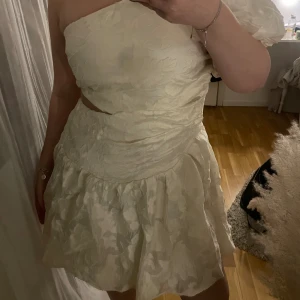 Vit studentklänning med blommor - Säljer en krämvit studentklänning med blommor på. Säljer denna då den inte passade mig. Endast testad en gång