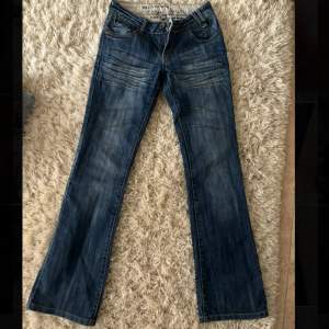 Supercoola blå lågmidjade jeans med voola silver detaljer längst benen! Unika bakfickor med knappar. Midjemått 37 och benlängt 101😋