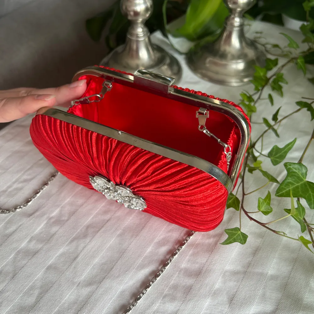Denna charmiga röda väskan har aldrig använts, den är tålig och gjord av metall med jätte fint tyg runt om. Är osäker på vart den är köpt då det inte står något på den.. Väskor.