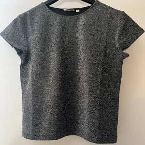 glitter topp - säljer denna jättefina glitter toppen från kappahl i storlek 146/152 men skulle säga att den sitter som xxs/xs, säljer då den är för liten, väldigt bra skick bara använd en gång! skriv för fler bilder, köparen står för frakten