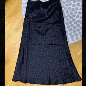 Kjol med leopardmönster - Säljer en helt ny kjol, lite glansigt i materialet.