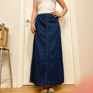 🍒MAXIKJOL🍒 - 🍒90’s CUTIE🍒Trendig 90-tals maxikjol i 100% denim med knappar i sidan. En liten vit knut i tyget som defekt på baksidan, men syns bara om man tittar nära, annars i jättefint skick. Modellen är 172cm lång för ref.🍒 