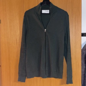 Selected Homme cardigan - Jag säljer min tunnt stickade cardigan från Selected homme då jag inte längre kan ha den. Den är i en väldigt snygg mörkgrön färg och är i storlek S. 