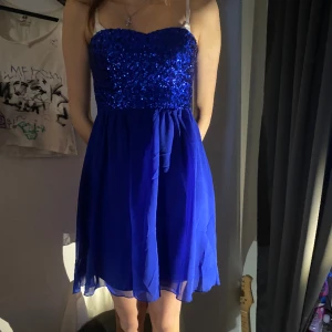 Festklänning - Blå kort festklänning med glitterpaljetter upptill. Nästan oanvänd och väldigt bra skick🥰 säljer pågrund av att den inte kommer till användning 