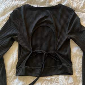 Jättefin svart tröja med öppen rygg. Den har slits i båda armarna. Ribbad i materialet.💕