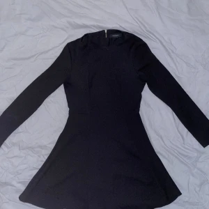 Atmosphere - Svart långärmad klänning  - En svart långärmad klänning med dragkedja längs ryggen. Storlek 36. Knappt använd. 