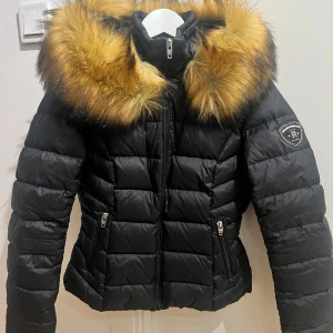 Dunjacka med päls RockAndBlue - I stort sett oanvänd lättviktsdunkjacka med päls (räv) inköpt hösten 2021 på Jeansbolaget för 2499 kr till då 14 åring. Storlek 38 men liten i storlek skulle jag säga. Använd fåtal gånger och därefter hängt i garderob. Nyskick! 