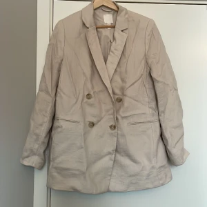 Kavaj i linnekvalitet - Dubbelknäppt kavaj i linnekvalitet. Sparsamt använd .