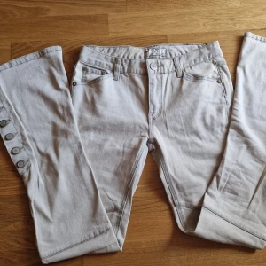 Lågmidjade Free people Jeans med fina detaljer - Sjukt snygga jeans som inte passar på mig :( Lågmidjade med fin bootcut, knappar i sidan så man kan knäppa ut för med vidd. snygga detaljer på fickorna  och sömmar runt knäna