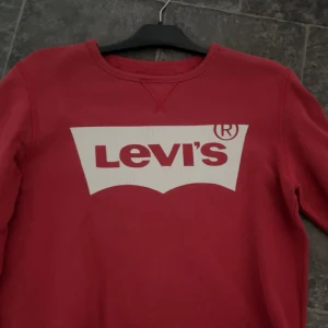 Levis sweatshirt  - Röd Levis sweatshirt, skick 7/10 har ganska med defekter på märket, storlek: M