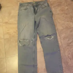 Ljusblå Gina tricot jeans med slitningar på knäna, i storlek 42 säljs för 130 kr