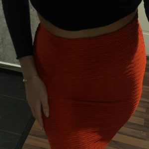 Röd/orange kjol  - En kort mini kjol, med mönster i tyget. Stretchig och skön. 🌺