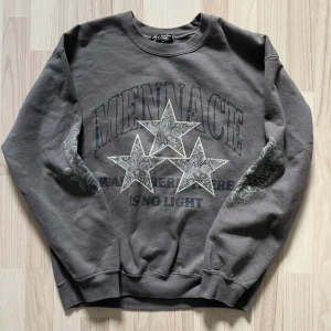 Mörk Grå Menace Sweatshirt - 149kr - Mörk grå sweatshirt i storlek small. 50% bomull, 50% polyester blend. Stort svart och grått ”MENACE WALK THERE IS NO LIGHT” & ”tre grå stjärnor med mönster” tryck över hela framsidan. För mått/fler bilder skriv privat.