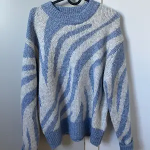 Stickad tröja från Gina Tricot med blått och beigt zebra mönster. Använd enstaka gånger, och normal i storleken 