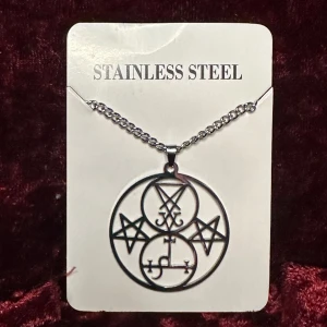 Nytt halsband Lucifers sigill Lilith Pentagram Ockult Wicca Stainless Metal Goth Rock Punk - Nytt silverfärgat halsband i rostfritt stål med amulett med mäktiga ockulta motiv.  Stilrent, vackert och ovanligt. Ett statementsmycke om något.  Amuletten är 5 cm lång och 4 cm bred.  Kedjan är 54 cm lång. Låses med hummerlås. Nytt och oanvänt.