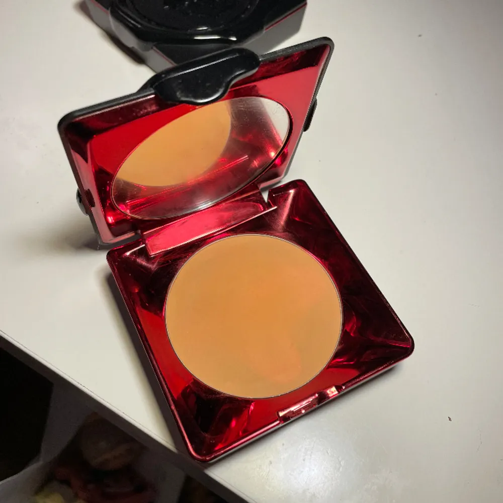 Kat Von D Lock-it puder.  Färg: Tan Deep 180   Swatchat. Och fått nån liten skada i pudret. Se bild.  För mörk för mig :(   Kan hämtas i Trollhättan eller skickas med Plick!. Övrigt.