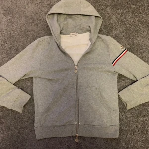 Moncler Zip Hoodie grå - Moncler zip-hoodie av modellen Maglia Cardigan. Riktigt fet dock lite gammal modell. Skick 8/10 Strl: M