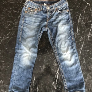 True religion jeans ”capri” - Säljer nu mina gamla true religion jeans då de bara har samlat damm och inte kommer till användning längre. Har inte kvar kvitto eller prislapp och annat tillbehör, de är ganska slitna och har ett hål på vänstra knät. Priset går att diskutera.