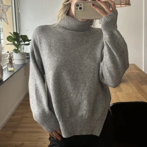 Grå tröja - Stickad tröja från H&M med slits på sidorna och turtleneck. 