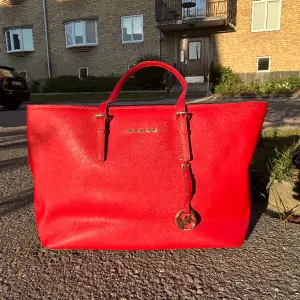 Röd Michael Kors Jet Set i nyskick. Använd 1 gång, har sedan dess legat i garderoben.   Nypris 2999kr