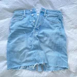 Jeanskjol  - En ljusblå jeanskjol med flera knappar