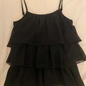 Volang linne - Söt svart linne med volanger. Aldrig använt inte min stil typ. Pris kan diskuteras 