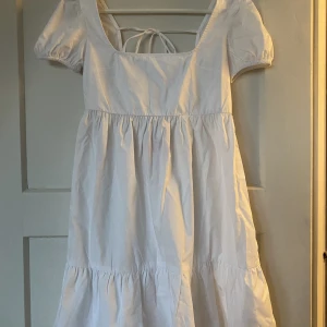 Supersnygg sommarklänning  - Supersnygg vit sommarklänning med knytning i ryggen. Aldrig använd bara testad så lappen sitter kvar. Köpt i Kroatien förra sommaren. Perfekt till skolavslutningen, konfirmationen eller studenten.💗Hör av dig vid frågor och funderingar!💗