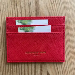 Röd plånbok med många fack. Aldrig använd. Säljs pga köp av en annan färg.