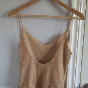 Glittrig body - Fin guldglittrig body, dröm att matcha med guldsmycken!🥰 strl M, skriv om du har ytterligare frågor❤