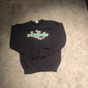 Powderpuff Sweater - Det är en snygg powderpuff sweater med en cool design både på ryggen och magen den har inga defekter annat än att trycken är lite spruckna fast inte särskilt mycket.