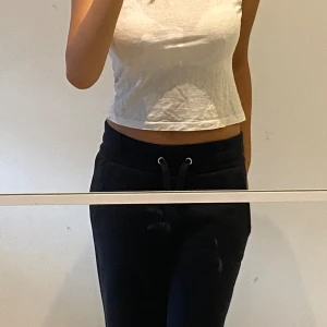 Vit kortärmad topp - En vit kortärmad topp med en tight passform. Toppen är croppad och har en rund halsringning.