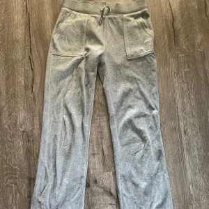 Juicy Couture byxor - Gråa mjukisbyxor från Juicy. Väl använda men i helt okej skick bortsett från en fläck på höger bakficka (se bild). Passar dig som är 170-175 cm lång. (Jag är 175) 